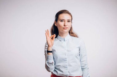 Genç kadın birkaç ifadeleri, gösterilen beyaz arka plan üzerinde izole jest Tamam, gösterir.