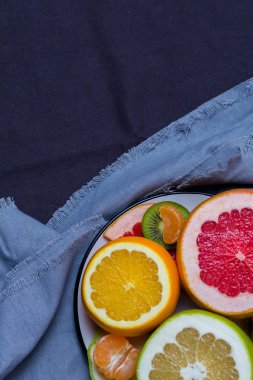 Narenciye meyve parlak plaka koyu mavi bir arka plan üzerinde renkli parçaları