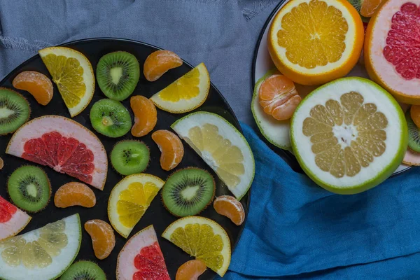 Many Citrus Fruits Sliced Two Plates Black White Half Grapefruit — Stock Photo, Image