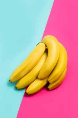 Pembe ve mavi zemin üzerine muz kümesinin kapatın. Meyve, gıda, sağlık ve minimalizm kavramları