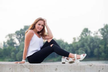 Yaz aylarında Doğa Park arka plan üzerinde kameraya bakarak neşeli gülümseyen kadın.