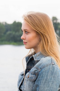 Doğada sarışın güzel genç kadın portresi yana yakından