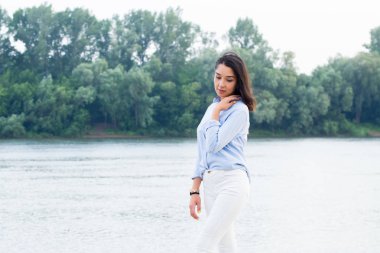 Doğada Nehri yakınında güzel Asyalı esmer kadın. Kız rüya ve aşağı bakıyor