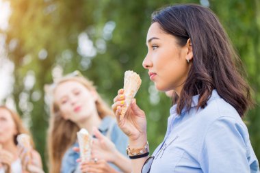 İçinde bir satır gülümseyen bir mesire ayakta üzerinde üç neşeli genç kız mutlu yaz tatile dondurma koni ye. Yakın çekim