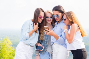 Akıllı telefonlar, Internet, uygulamalar ve iletileri kullanımı. Güzel kız bir grup bak telefon kız ve gülmek, sürpriz