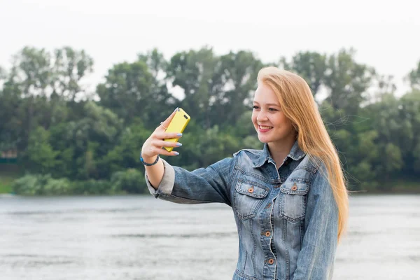 かなり若いブロンドの女性の笑顔で 自然の背景に Selfie を服用します 肯定的な感情 学生生活の概念 — ストック写真