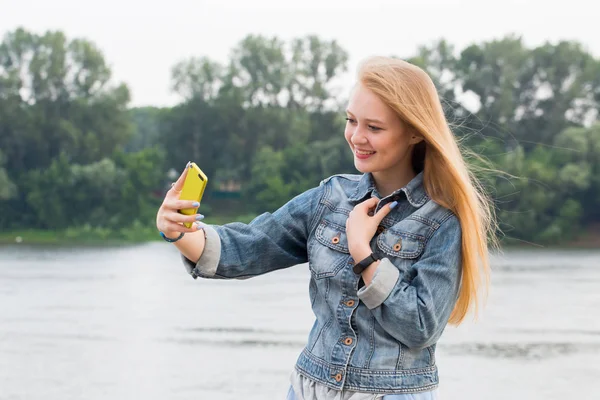自然公園の中のスマート フォンで Selfies を取っている女の子のポートレート クローズ アップ 現代の技術 ライフ スタイル コンセプト — ストック写真