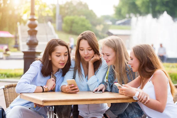 Cuatro Mujeres Jóvenes Atractivas Usan Teléfonos Inteligentes Una Mesa Parque — Foto de Stock