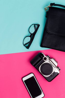 Portre fotoğraf makinesi, smartphone, gözlük ve renkli arka plan, üstten görünüm üzerinde siyah kadın sürtük. Dinlenmek, dinlenmek, eğlence, seyahat ve hobi kavramı