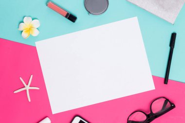 Bayan aksesuarlar, üstten görünüm renkli bir pembe ve mavi zemin üzerine beyaz A4 boş çerçeve. Ruj, ayna, sarı çiçek, Gözlük, kalem, kabukları yalan fotoğraf çevresinde