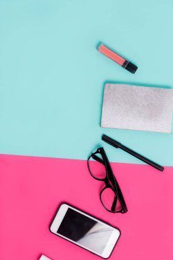 Bayan büro malzemeleri pembe ve mavi arka plan üzerinde. Düz yatıyordu, en iyi görünüm. Minimalizm