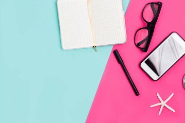 Ofis Büro Kırtasiye, gözlük ve akıllı telefon ile kapatın. Aksesuar bahar pembe ve pastel mavi arka plan kadın ile çalışmak