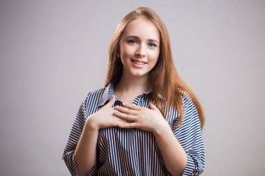 Dokunaklı bir an. Sevimli genç öğrenci kız gülümseyen, sürpriz, mutlu Haberler, Doğum günü hediyesi ya da yeni yıl ve göğsünde uygulanan eller. İnsan duyguları, yüz ifadesi, mutluluk kavramı.