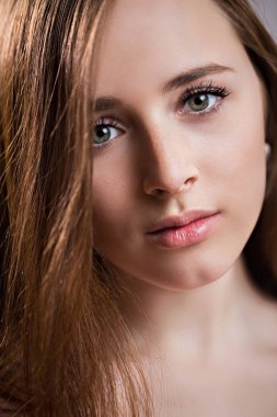 Closeup yüzü çilli olan güzel kızıl saçlı kadın. Temiz cilt, doğal güzellikleri ile çekici kız kameraya doğru görünüyor. Düzgün kaşları, uzun kirpikler