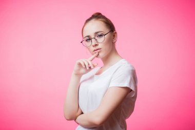 Bir güzel sevimli kırmızı saçlı kadın bir pembe gözlüklerle portresi. Beyaz t-shirt giyen genç kız