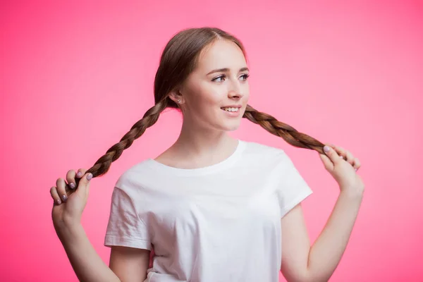 Joven Chica Atractiva Sosteniendo Largas Trenzas Con Una Sonrisa Mirando —  Fotos de Stock