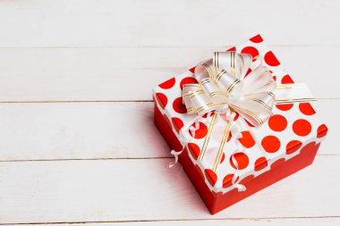 Güzel hediye paketleme, kırmızı kutusu ile şerit üzerinde beyaz tahta arka plan ile kopya alanı, üstten görünüm.