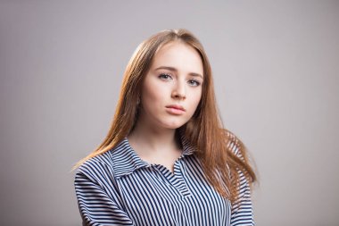 Portre çekici öğrenci kız kopya alanı ile gri arka plan üzerinde yatay portresi. Genç kadın ile doğal güzellik ve makyaj olmadan güvenle kameraya benziyor