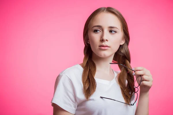 Hermosa Mujer Joven Sosteniendo Gafas Mirando Hacia Otro Lado Sobre —  Fotos de Stock