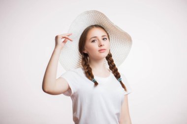 Kafa kameraya bakarak yaz bej şapkalı zencefil gülümseyen kadın portresi vurdu. Örgüler, genç kızla yakın çekim