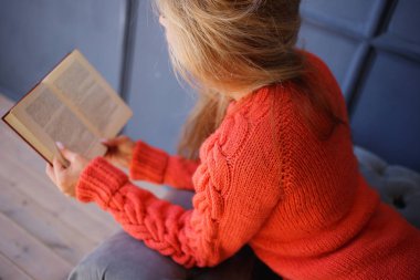 Güzel genç kadın evde pencere yakınındaki kitap okuma. Portre