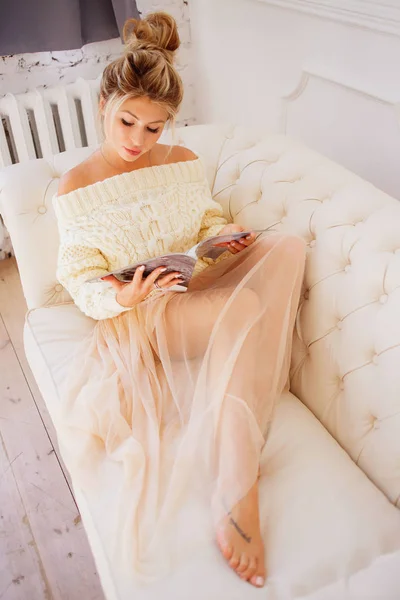 Ευτυχισμένη Γυναίκα Διαβάζει Ένα Περιοδικό Που Κάθεται Στον Καναπέ Στο — Φωτογραφία Αρχείου