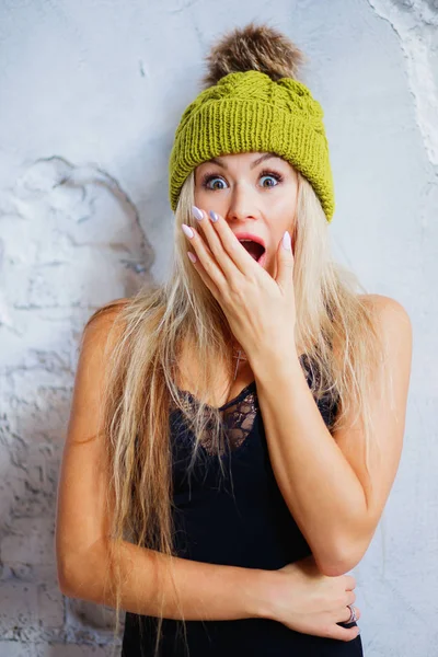 Shocked and surprised girl screaming covering mouth her hands. Beautiful girl with blonde hair and nails manicure. Presenting your product..Expressive facial expressions