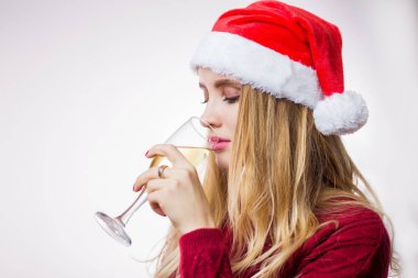 Noel Baba'nın kırmızı şapka ve örme kazak giyen ve beyaz arka plan üzerinde şampanya içmek sarışın genç kadın yana portresi. Noel, yeni yıl