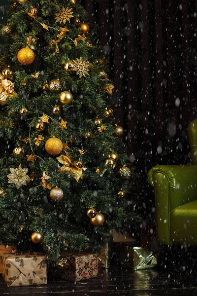 그린 크리스마스 트리 장식 나무 검은 바닥에 선물 상자와 함께 어둠 속에 갈색 벽 근처 골든 옐로우 콘 장식 — 스톡 사진