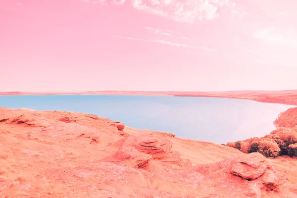 Beautiful blue lake on the background of coral coast and pink sky and white clouds