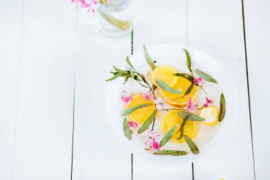 Kireç ve tropikal çiçeklerle dolu tabakta ayak banyosu, kaplıca pedikür tedavisi, üst manzara.
