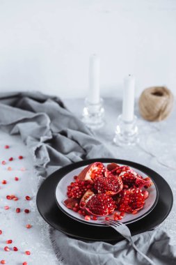 Nar bir plaka üzerinde gri bir havlu masaya kesilmiş. Sağlıklı gıda, beslenme, kahvaltı konsepti