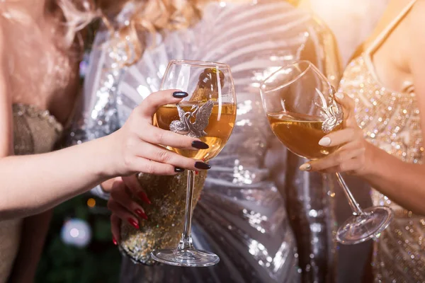Tungur bardak şampanya kar efektli parlak ışıklar arka plan üzerinde elinde. Tatil, yeni yıl, kutlama