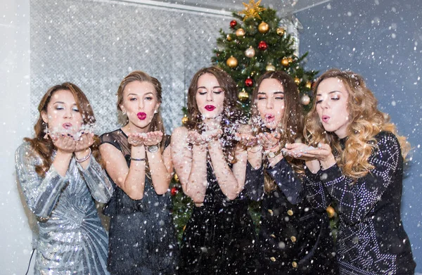 Belas Mulheres Jovens Divertindo Uma Festa Natal Soprando Confete Neve — Fotografia de Stock