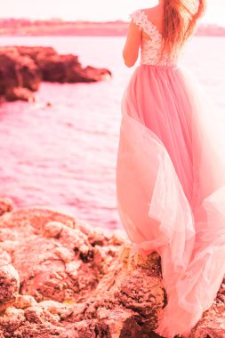 Güzel gelin denizde uzun pembe bir gelinlik. Moda renkler 2019, mercan yaşayan kavramı