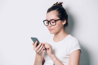 Neşeli genç kız öğrencinin cep telefonu, mobil internet'te sörf güzel kız kullanarak