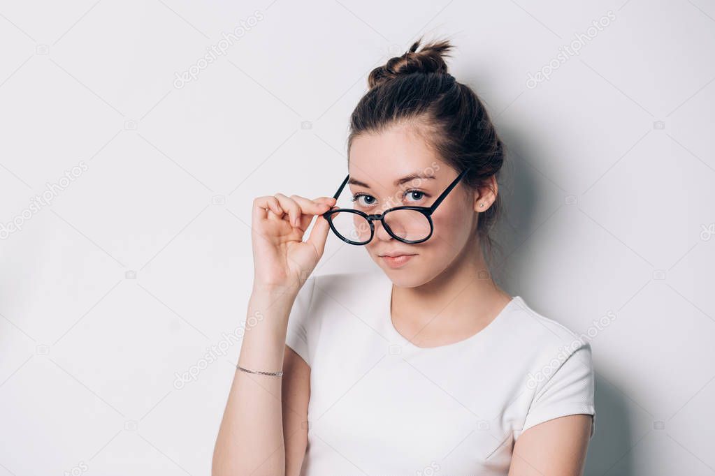 Pretty woman with round glasses looking at the camera on white background. Vision, view, health concepts