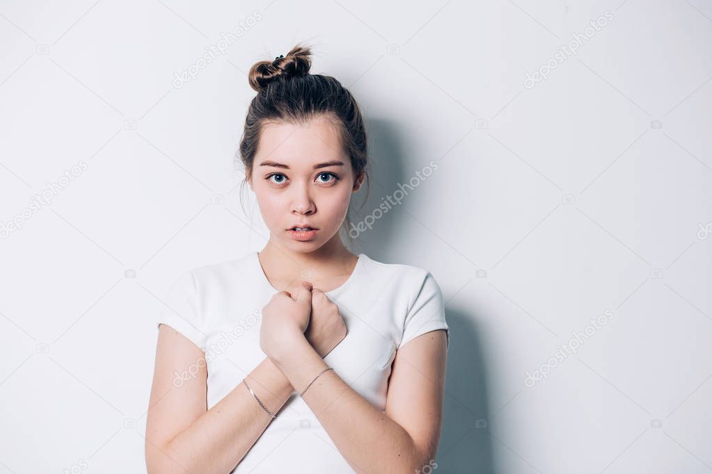 Porter young beautiful brunette woman crossing her arms and looking into the camera on a white background with copy space. Hope, desire, success of the concept