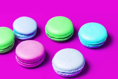 Ev yapımı çok tatlı tatlı macaroons masada mor arka plan üzerinde renkli. Renkli kek
