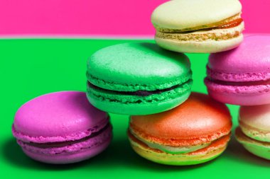 Portre renkli pembe, turuncu, yeşil. masanın üzerine bej Fransız tatlı macaroons. Makro fotoğraf kek