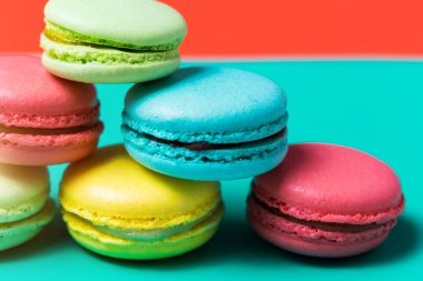 Renkli macarons kek üzerinde mavi arka plan, closeup pembe, yeşil Fransız tatlı kahvaltı için sarı.