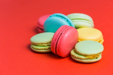 Tatlı yeşil, sarı, mercan, closeup macaroons kırmızı zemin üzerine mavi