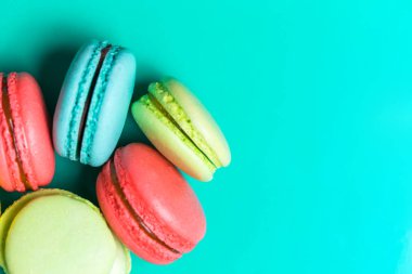 Closeup kopya alanı pudra, kafe, fırın için renkli bir turkuaz zemin üzerine farklı macaroons