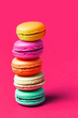 Pasta macaron veya acıbadem kurabiyesi pembe bir arka plan üzerinde Kapat
