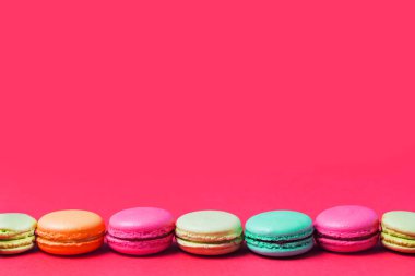 Parlak pembe renkli Fransızca mavi, turuncu, yeşil, bej macaroons, kopya alanı ile metin için.