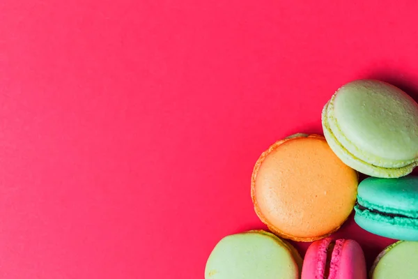 Beautiful bright pink background with French pastry macaroons, copy space.