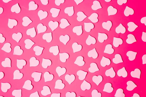 Flat lay of small hearts on a bright pink colored background. Valentine\'s day, love concept