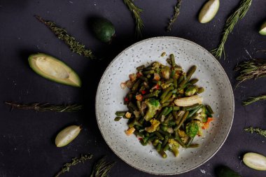 Kızarmış heyecan yat veya karanlık masaya bir tabak haşlanmış sebze kapatın, üstten görünüm