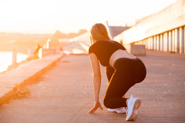 Atleta mujer en carrera empezar a posar en la calle de la ciudad. Chica en negro deporte apretado ropa . — Foto de Stock