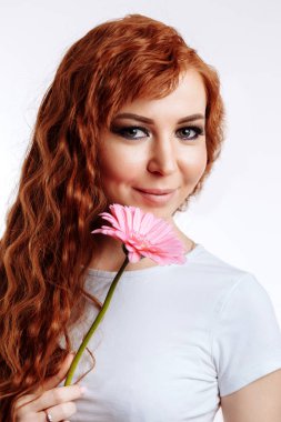 Gülümseyen ve çiçek tutan oldukça beyaz bir kadın portresi